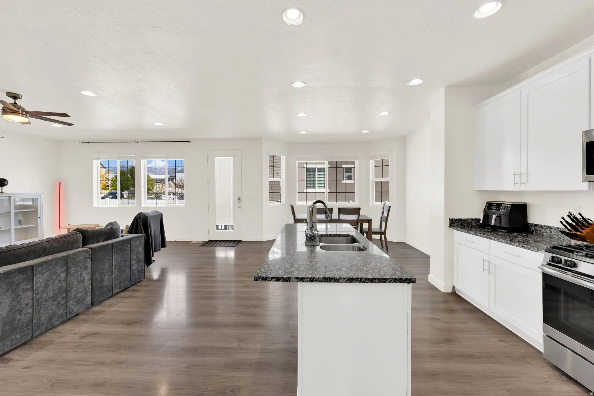 Kitchen with open floor plan, plenty of natural light, a kitchen island with sink, stainless steel range with gas cooktop, and recessed lighting