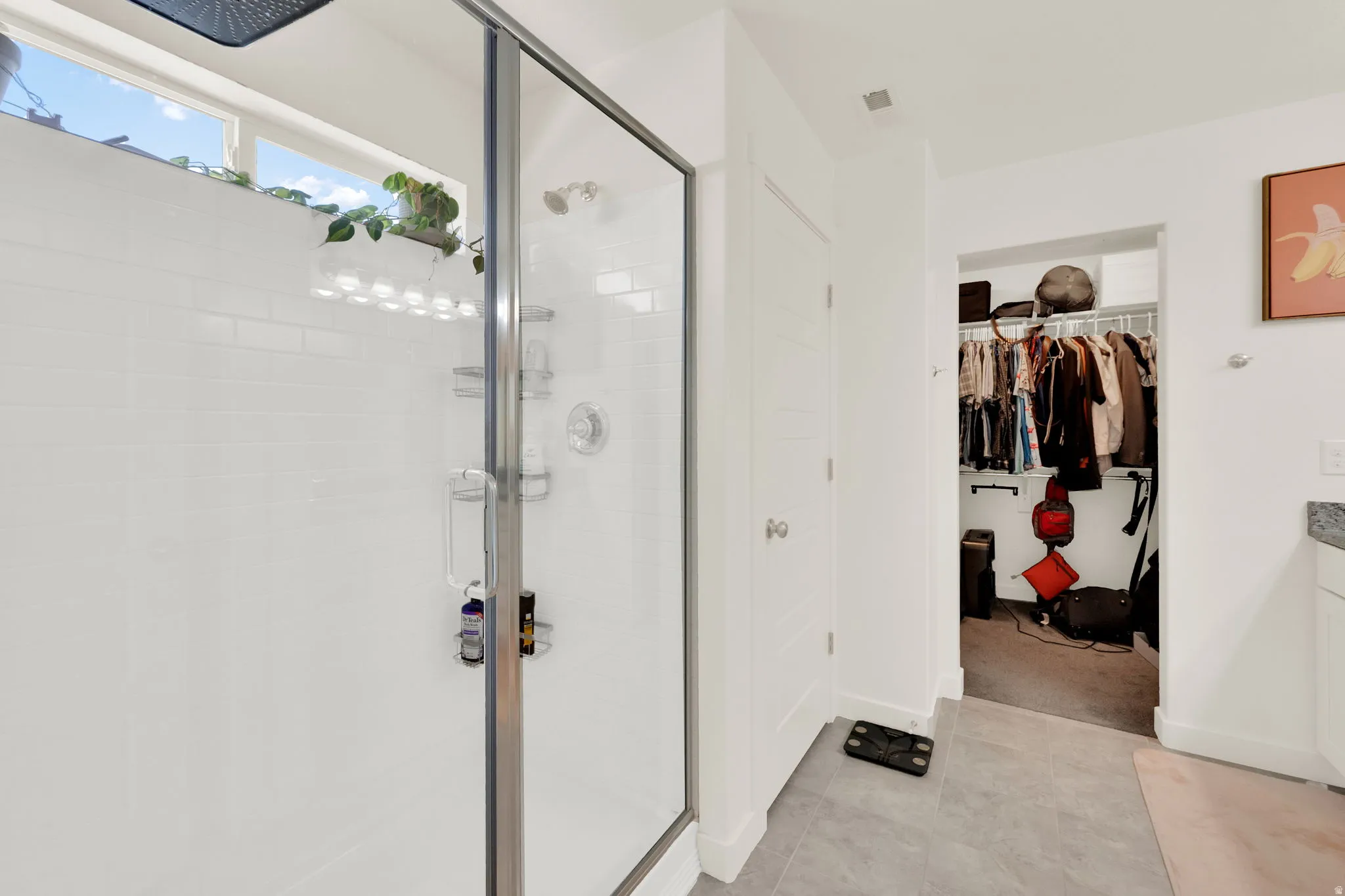Full bath with a walk in closet, vanity, and a shower stall