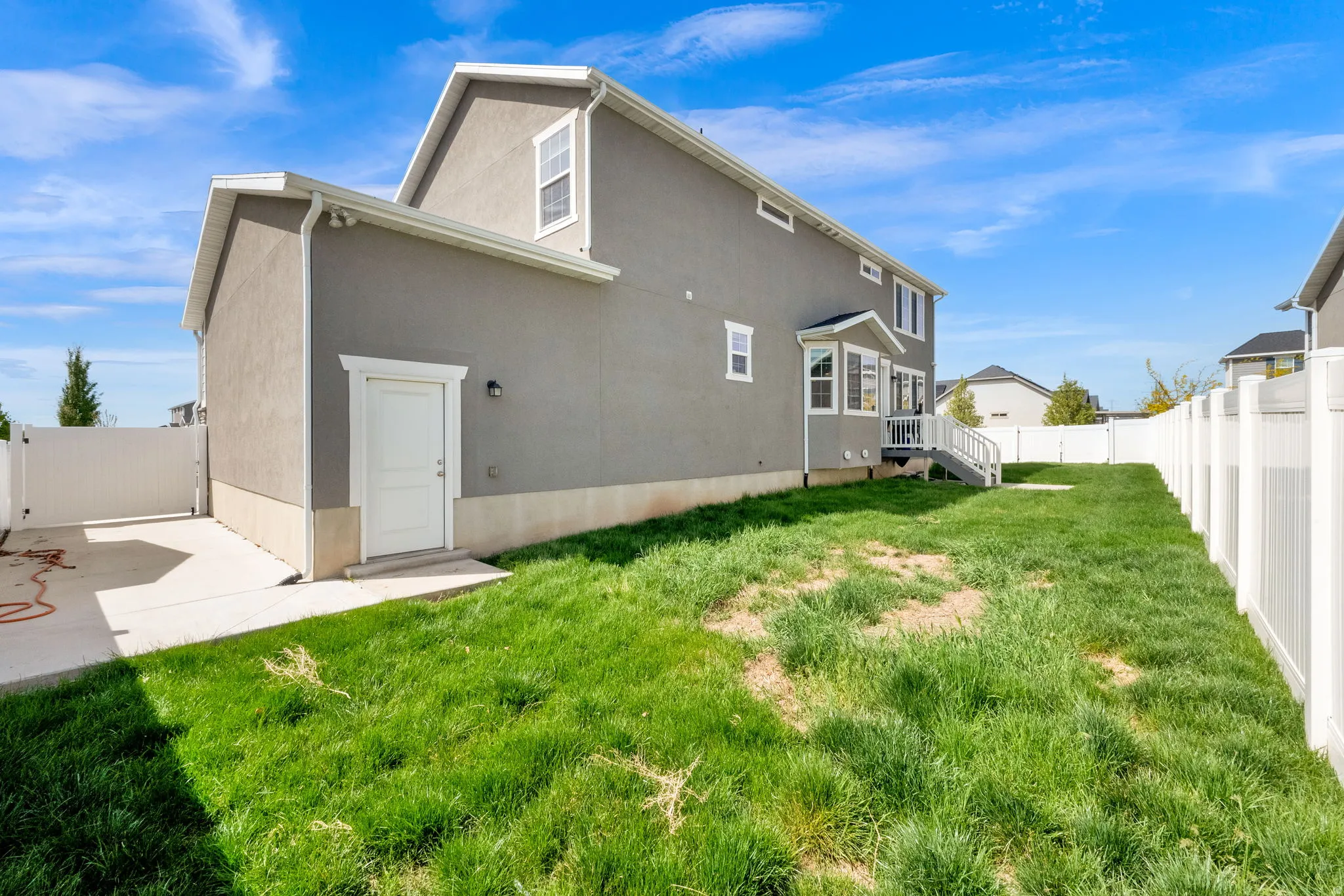 Back of house with a fenced backyard, stucco siding, and a gate