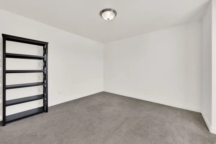 Spare room with dark colored carpet and baseboards
