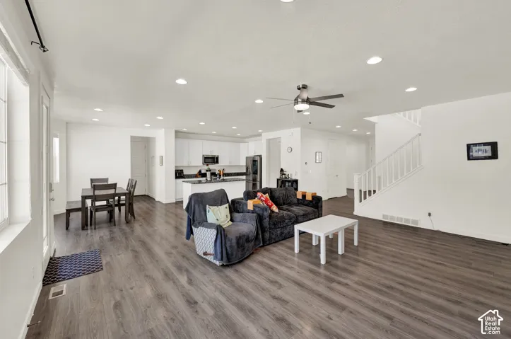 Living room with ceiling fan, dark wood-style floors, and recessed lighting