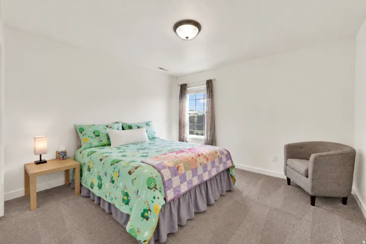 Neutral wall color, carpeted flooring, window with natural light, and ceiling-mounted light fixture