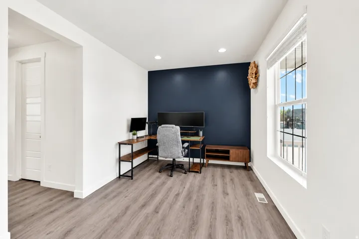 Recessed ceiling lighting, hard-surface flooring, and a single window with blinds