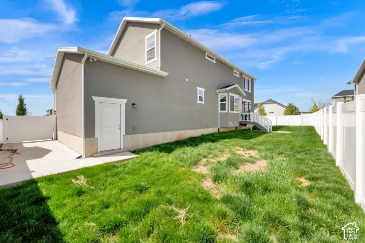 Back of house with a fenced backyard, stucco siding, and a gate