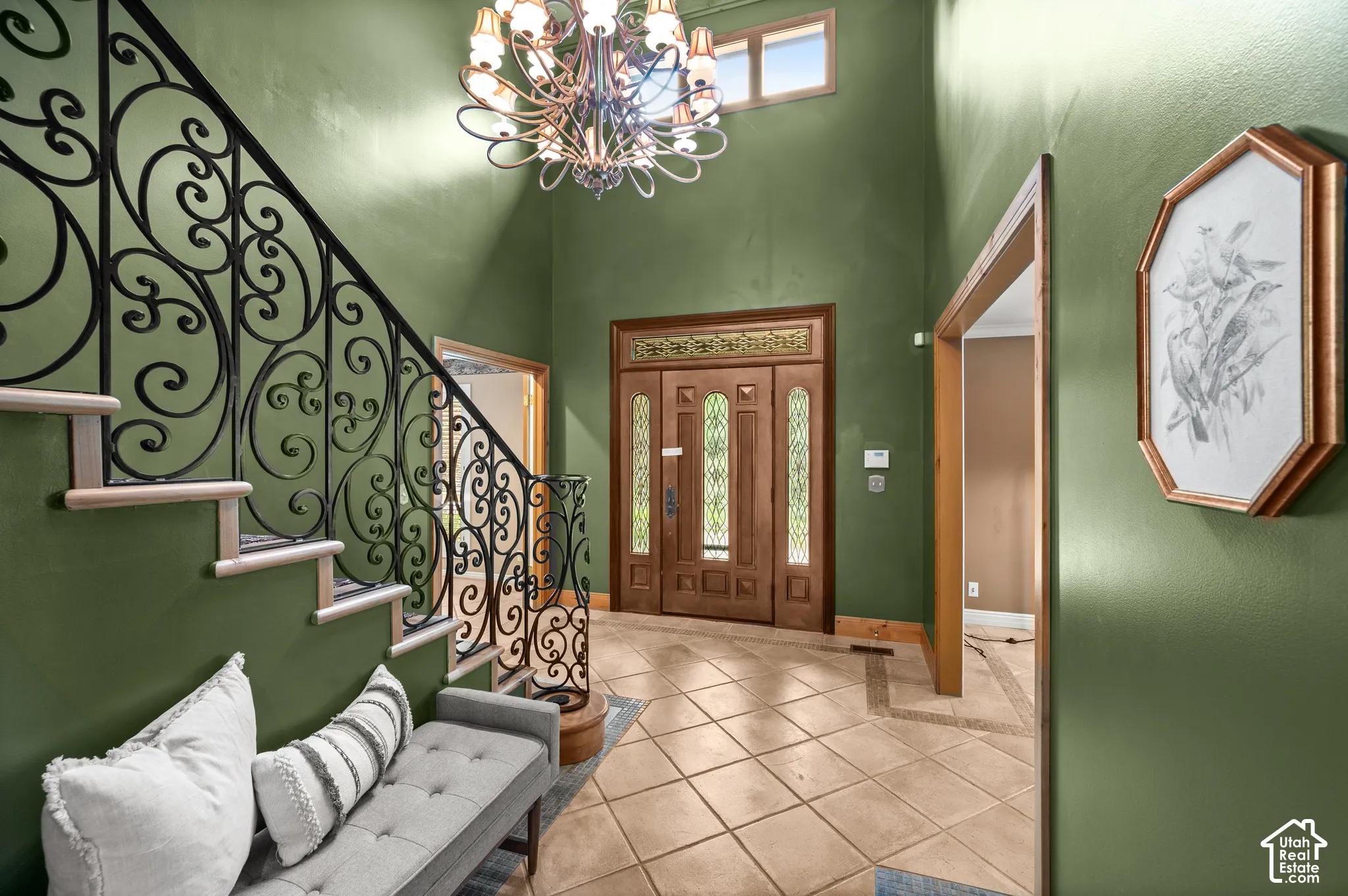 Grand foyer featuring a two-story ceiling, a decorative chandelier, and a wood-finish front door with glass panels