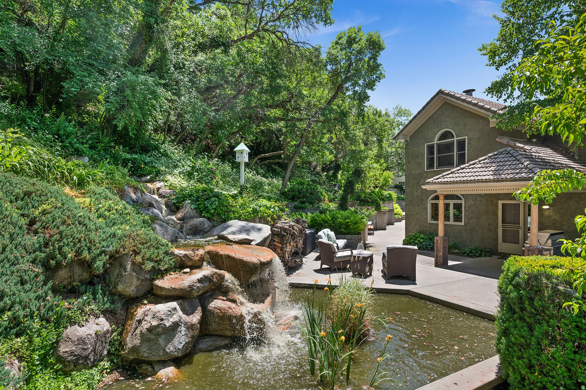 View of yard with a patio and a small pond, and waterfall.