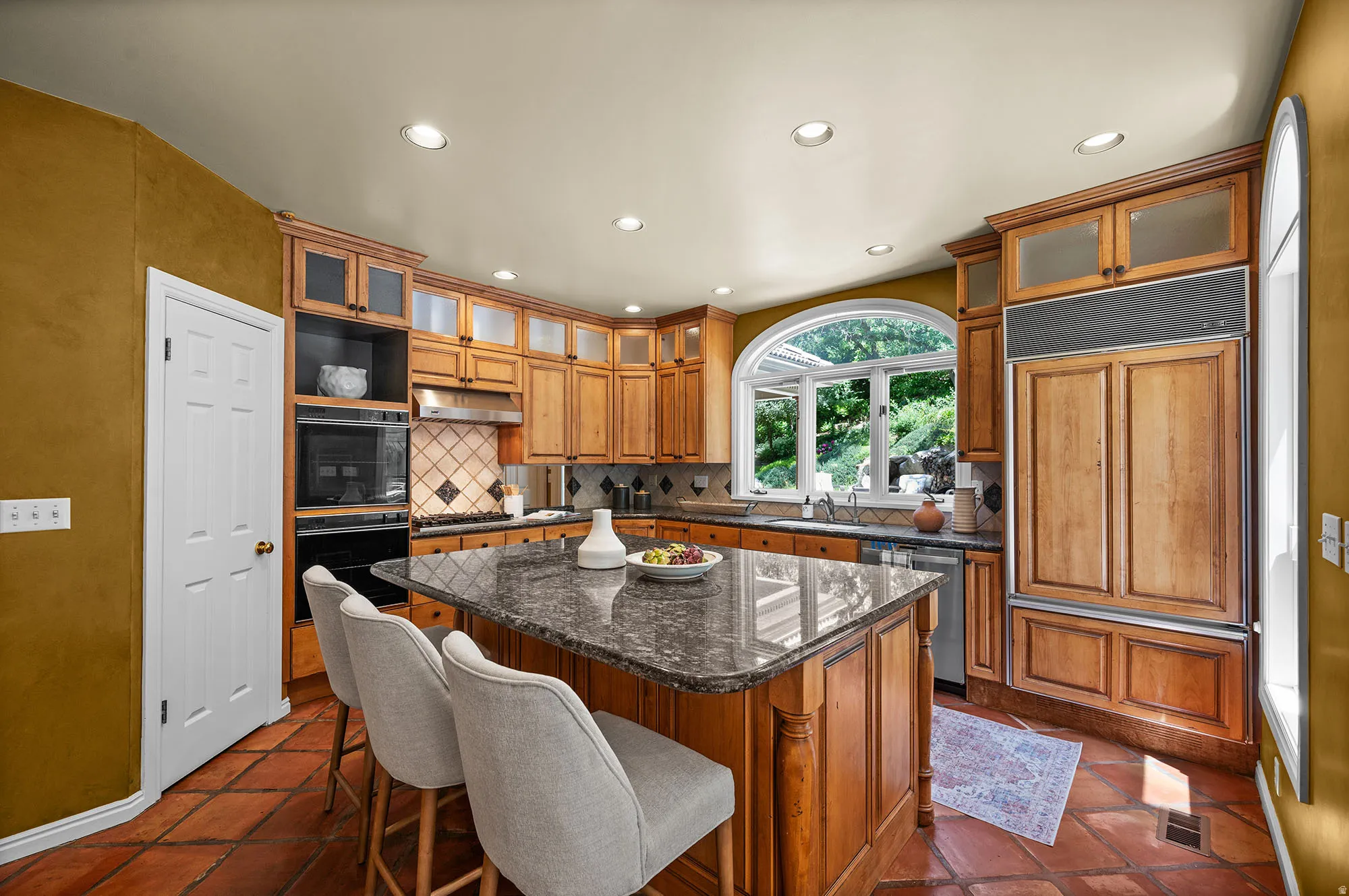 Kitchen featuring a breakfast bar area, dark stone counters, recessed lighting, and a center island