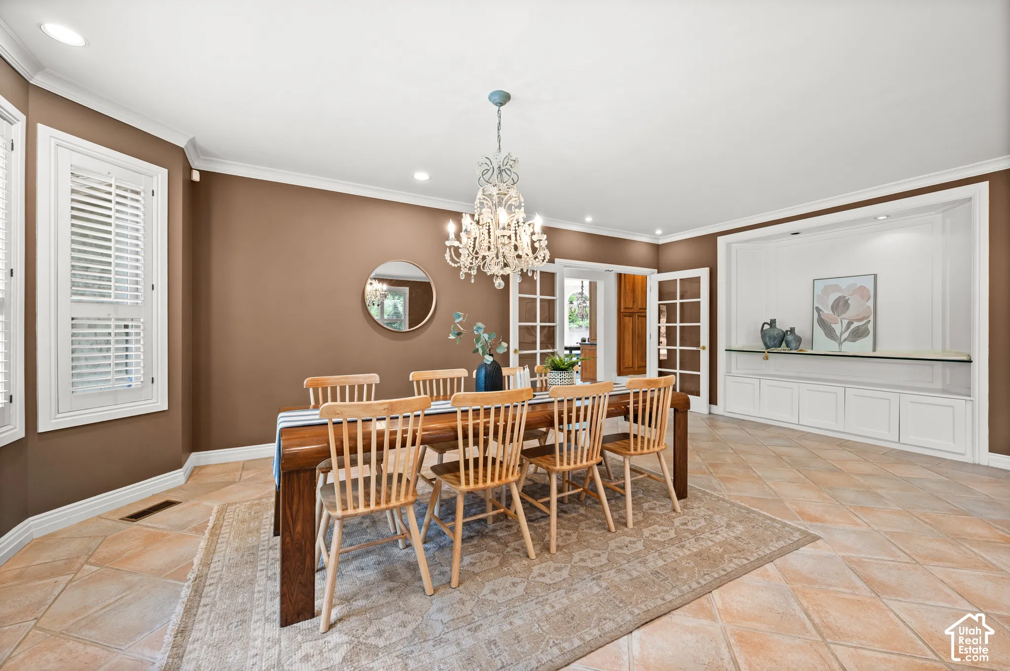 Spacious dining area featuring neutral tile flooring and crown molding