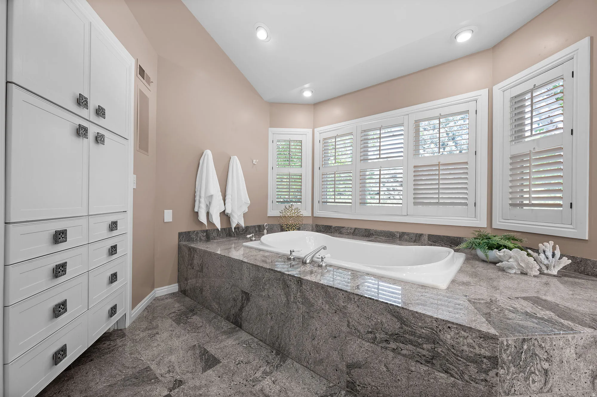 Bathroom featuring a garden tub/jetted and plenty of storage.