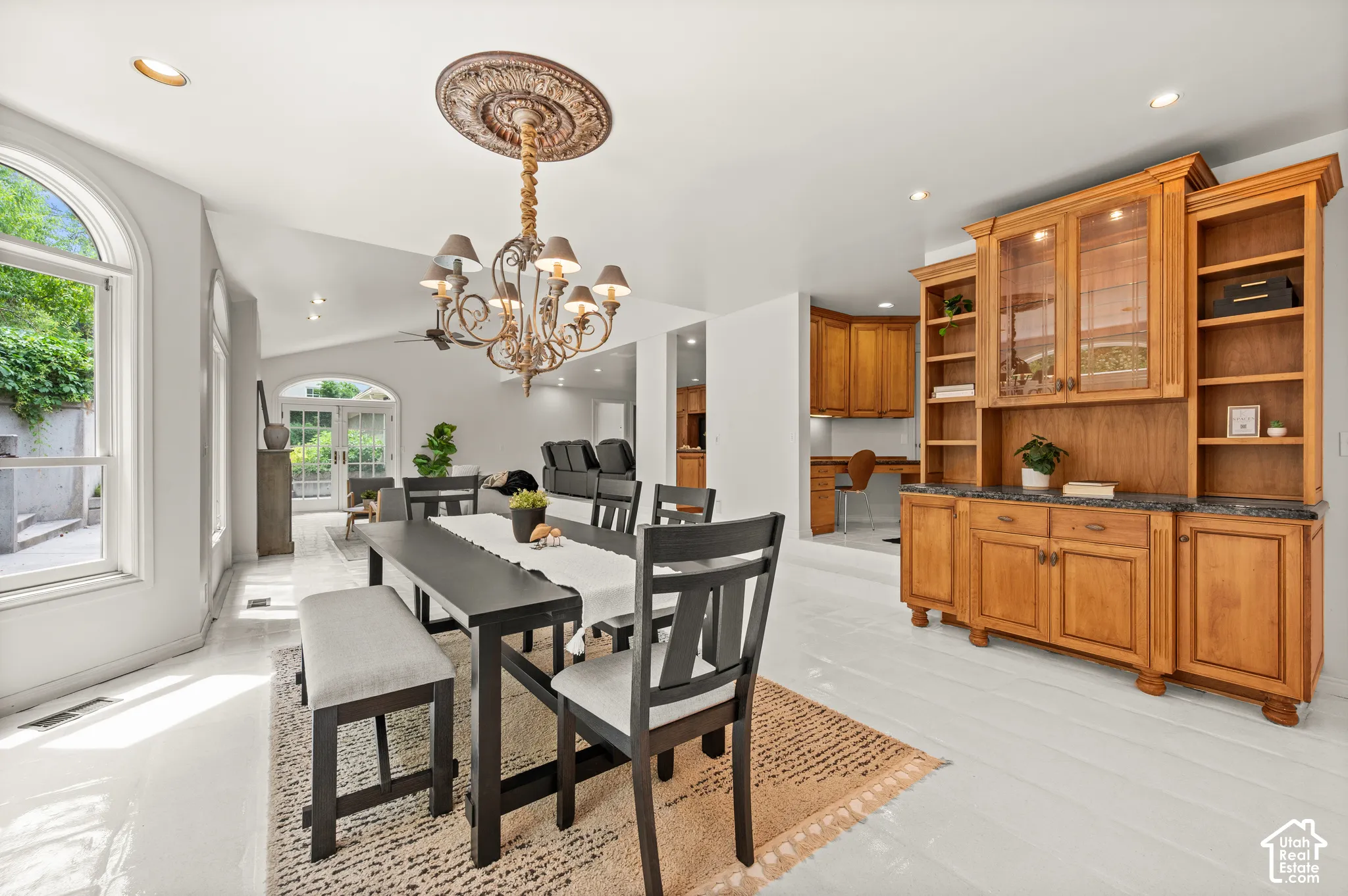 Kitchen dining area featuring light flooring and a central chandelier.