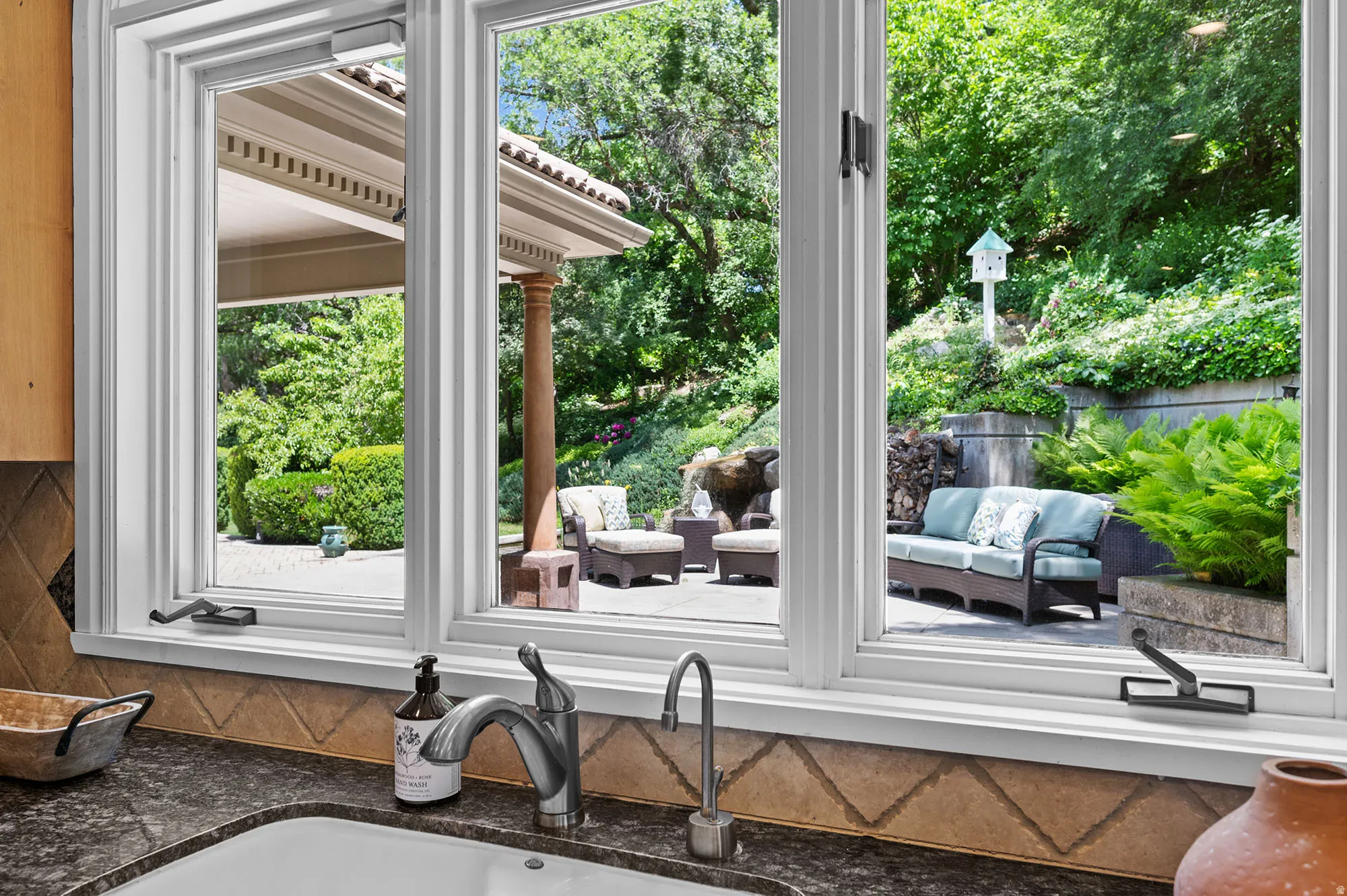 Kitchen view out to back patio and waterfall and fish pond.