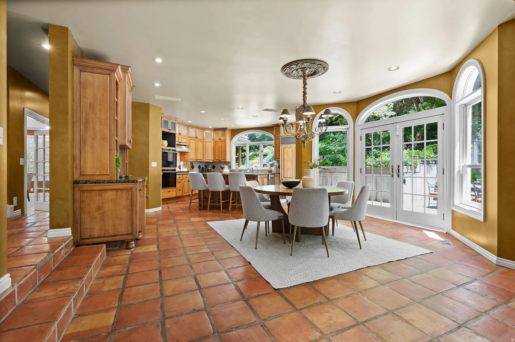 Kitchen dining area with a chandelier and french doors to exterior patio.
