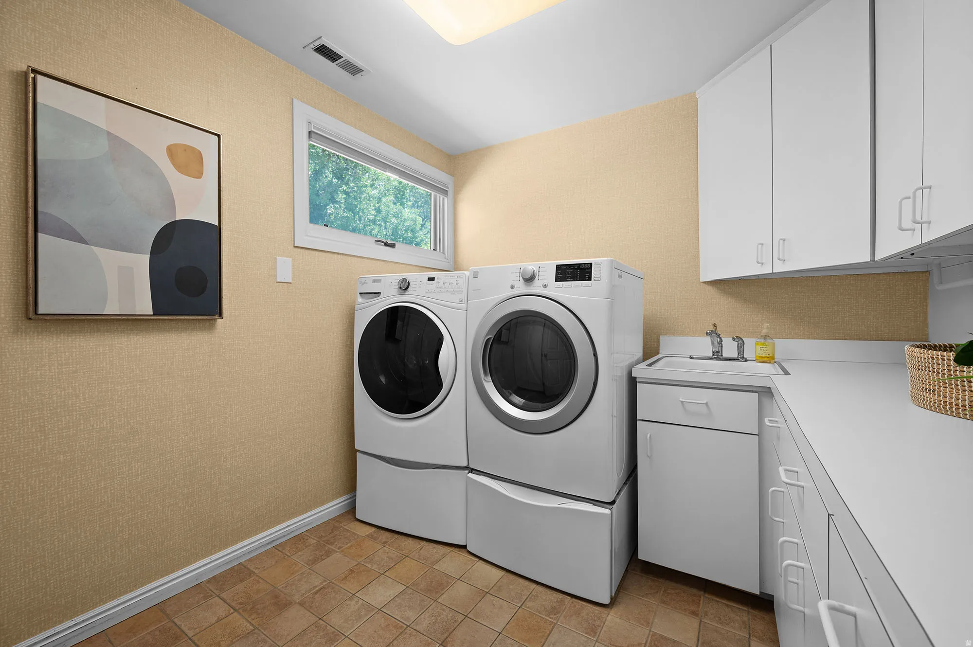 Laundry area featuring cabinet space, washing machine and dryer.  Included.