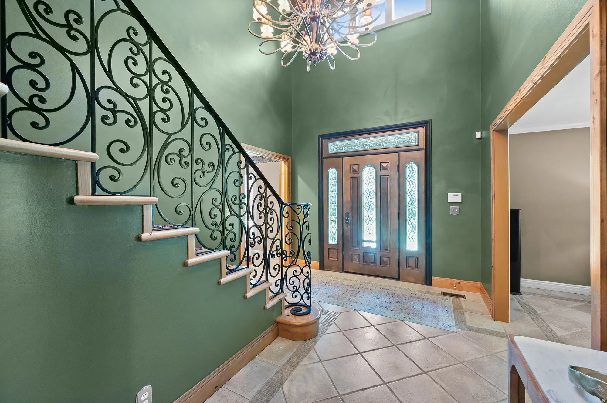 Foyer by front door with plenty of natural light, a chandelier, and high ceiling