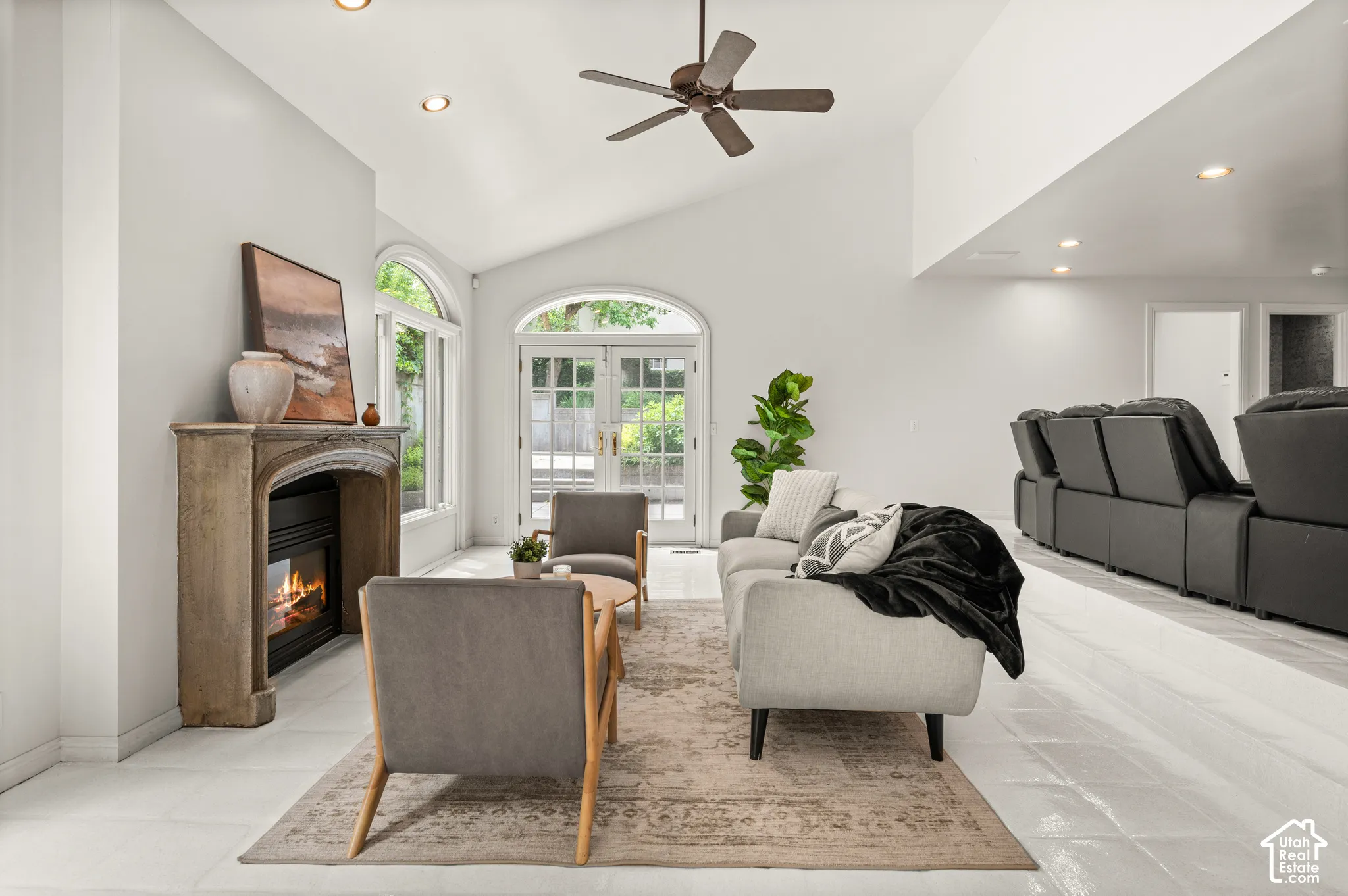 Spacious living area featuring a vaulted ceiling and recessed lighting with theater area behind.  2 sets of patio doors.
