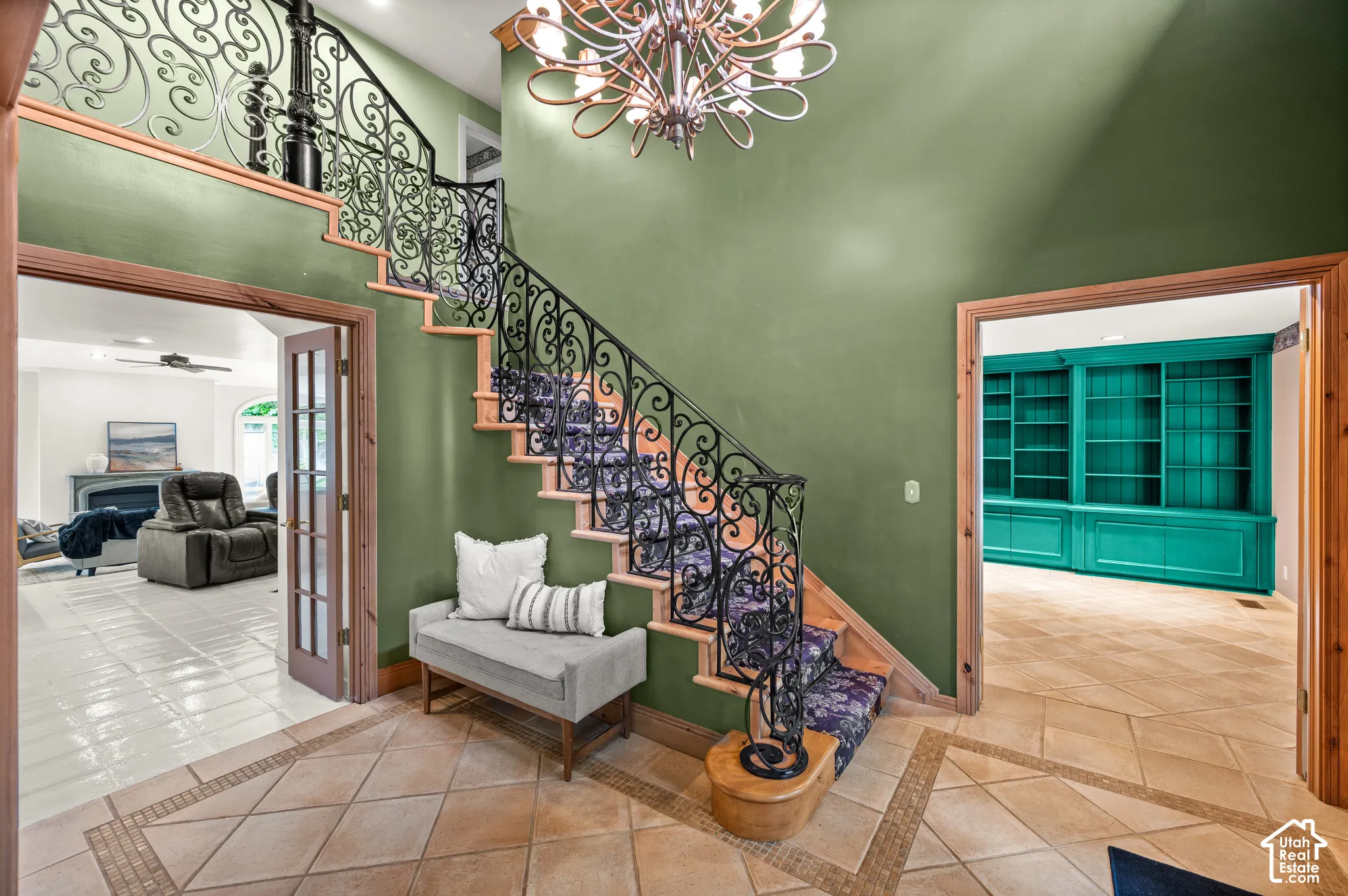 Grand foyer featuring a curved staircase with ornate wrought iron balusters and wood treads