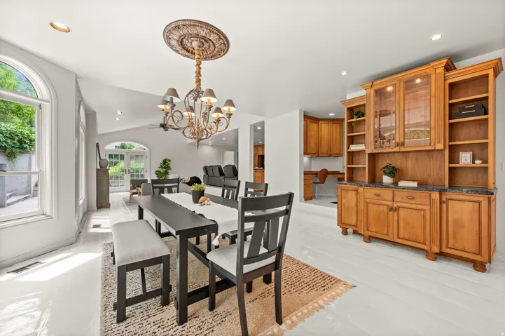 Kitchen dining area featuring light flooring and a central chandelier.