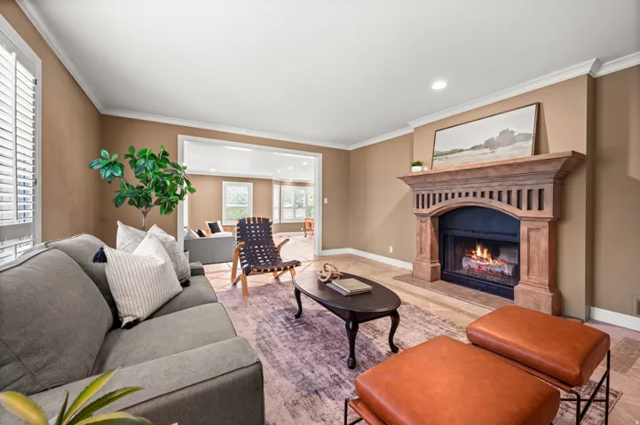 Living area with a carved wood fireplace mantel, an arched firebox, and tile hearth