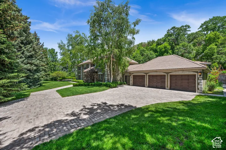 Front View with 3 Car Large Garage and cobble stone/brick driveway.