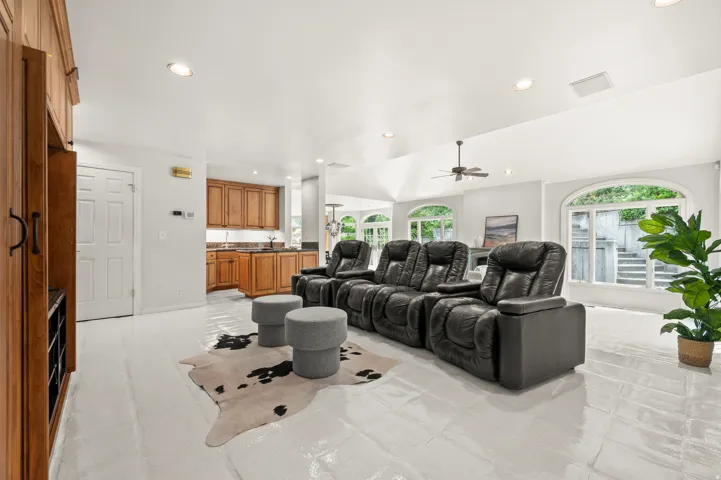 Expansive recreation room featuring light-toned flooring, recessed lighting, and a built-in media cabinet