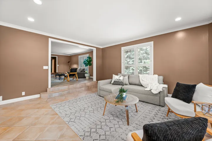 Living area featuring recessed lighting, crown molding, and a neutral color palette