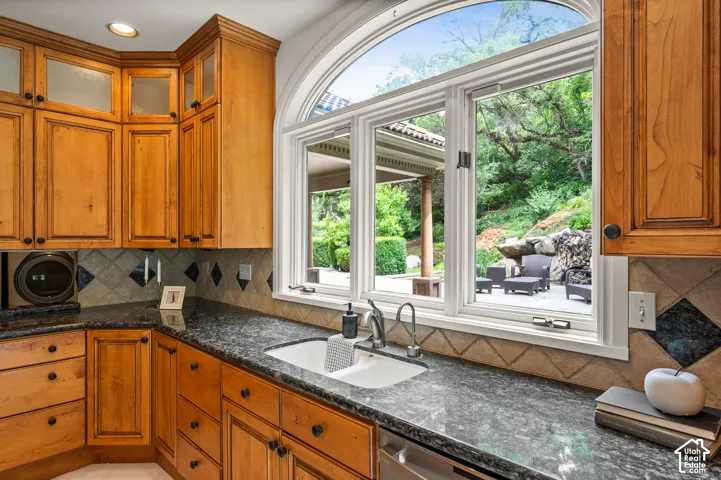 Kitchen workspace featuring extensive wood cabinetry, mottled countertops, an