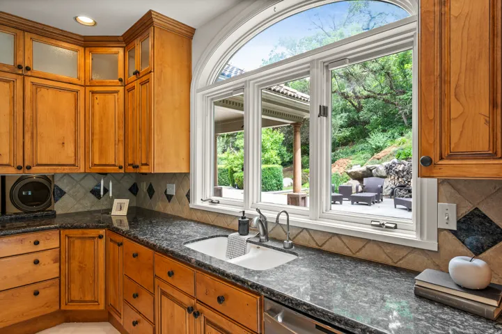 Kitchen workspace featuring extensive wood cabinetry, mottled countertops, an