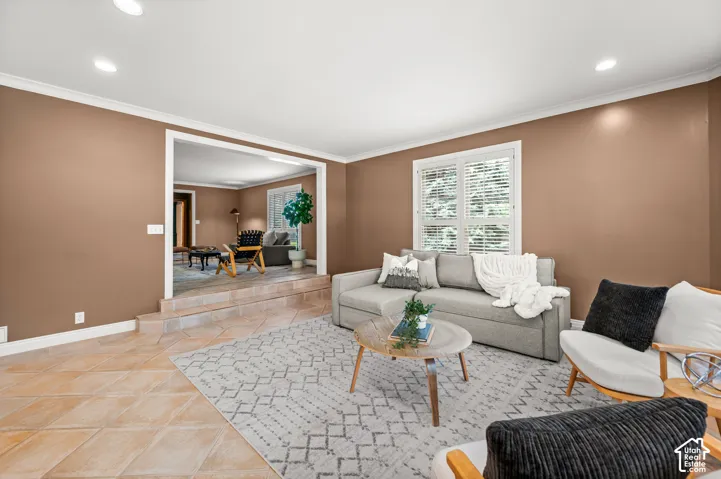 Living area featuring recessed lighting, crown molding, and a neutral color palette