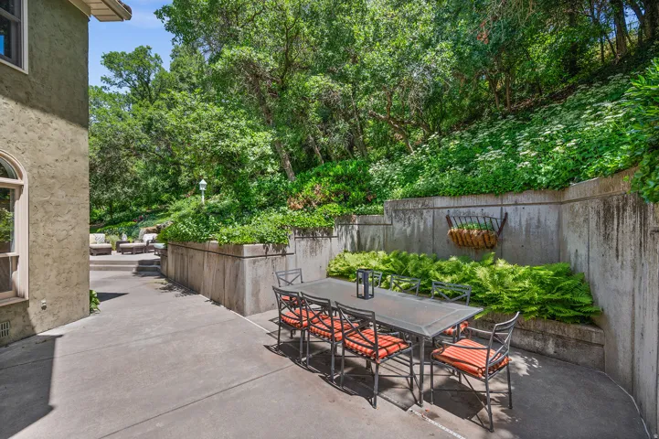 Beautiful outdoor dining area surrounded by ferns and ivy.