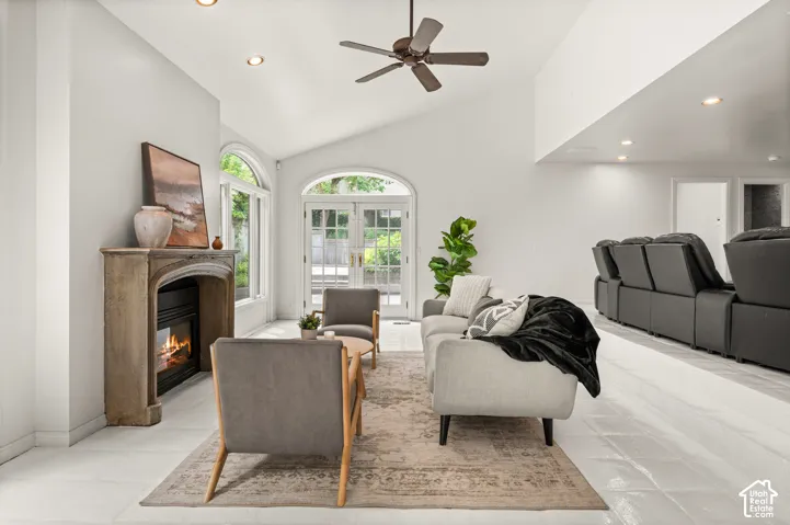 Spacious living area featuring a vaulted ceiling and recessed lighting with theater area behind.  2 sets of patio doors.