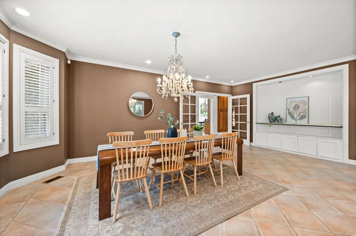 Spacious dining area featuring neutral tile flooring and crown molding