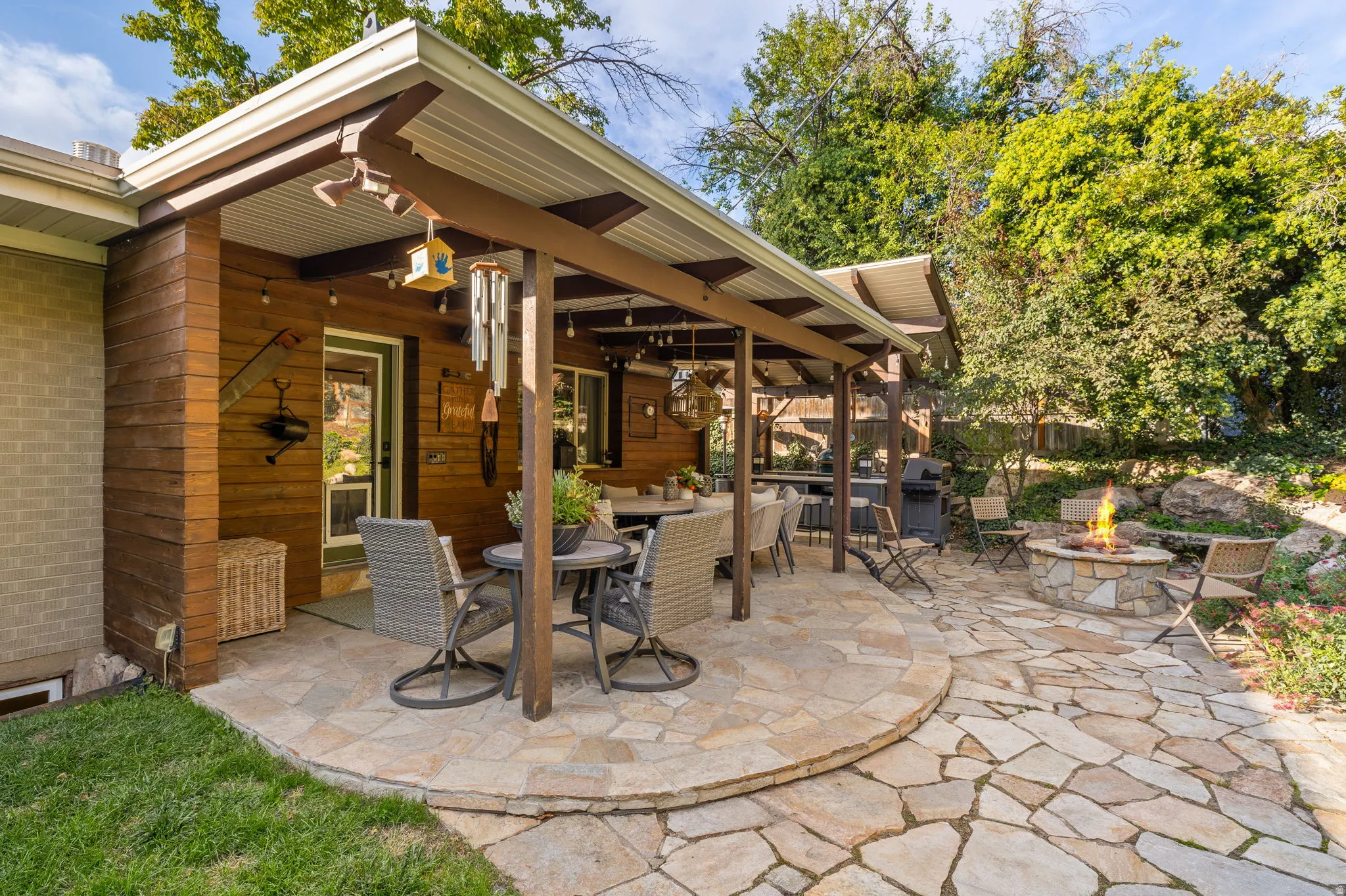 Backyard patio with hardwired heaters, firepit, dining space and kitchenette