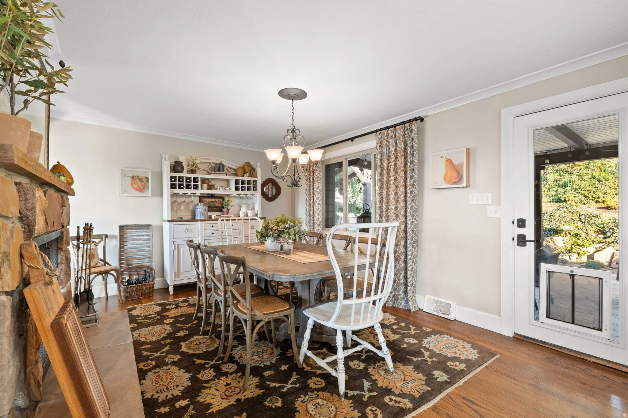 Dining room featuring hardwood floors, wood burning fireplace & access to backyard patio