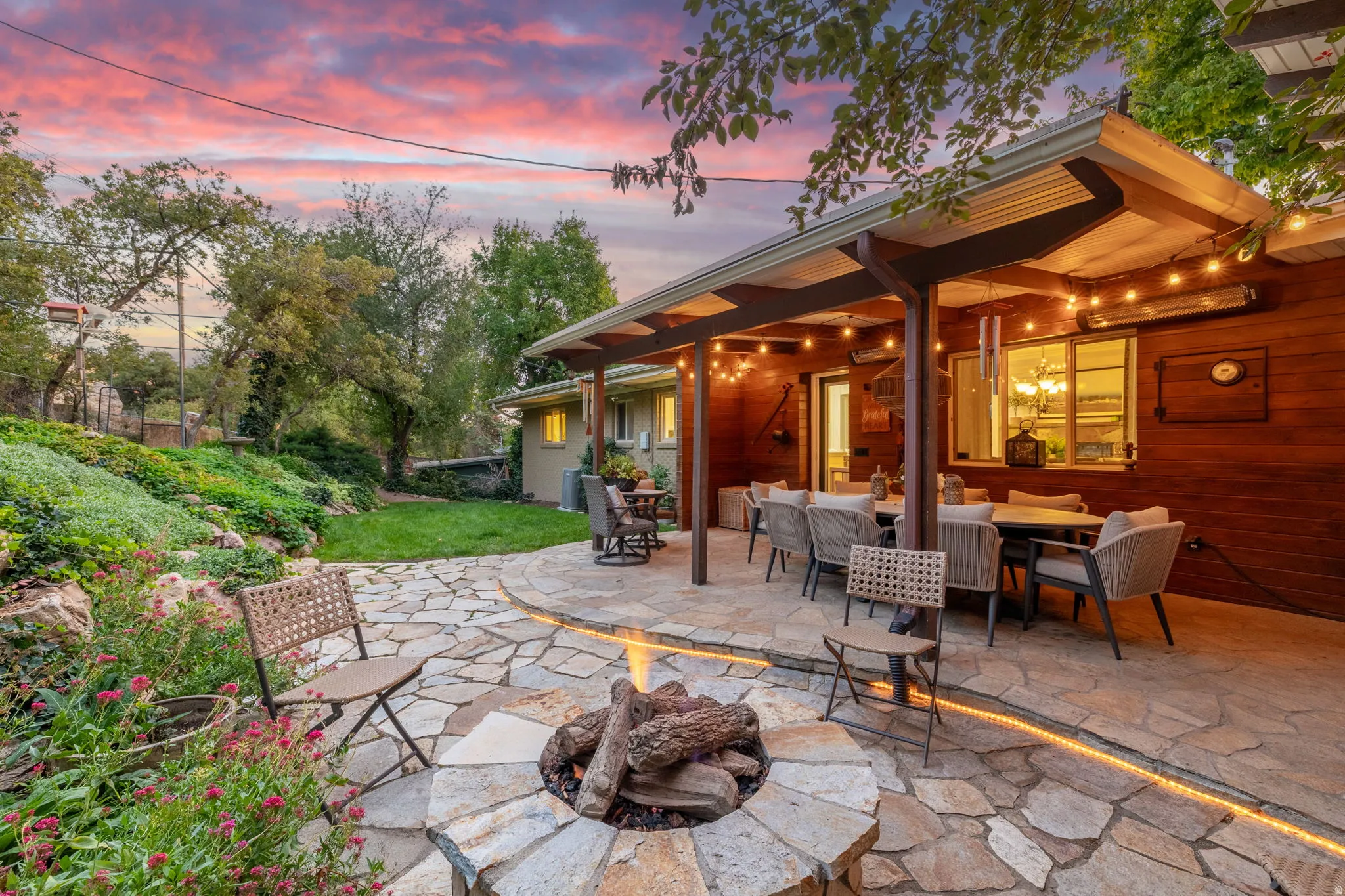 Backyard patio with hardwired heaters, firepit, dining space and kitchenette
