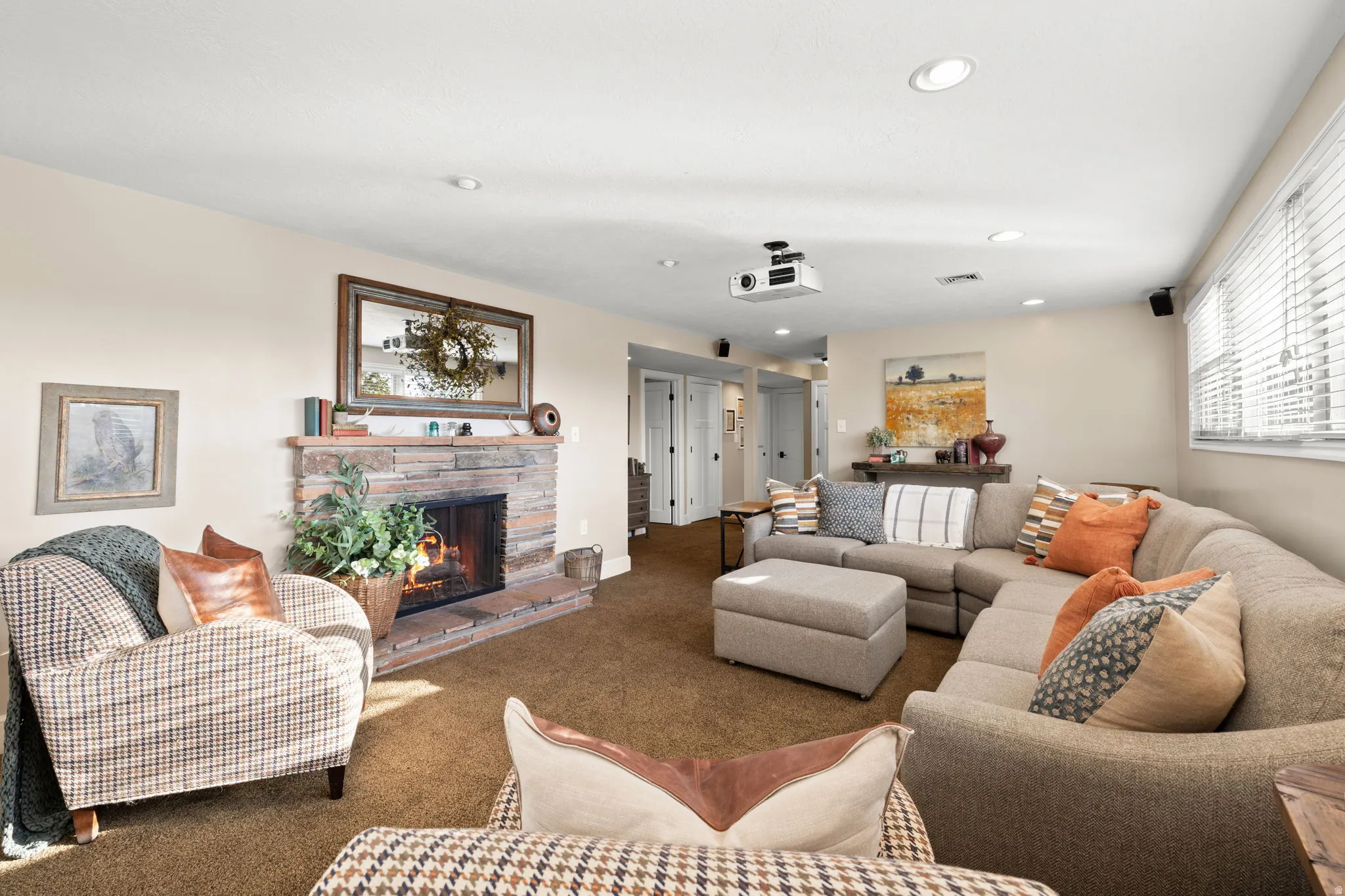 Lower level living room with expanded windows, gas fireplace and home theatre projector