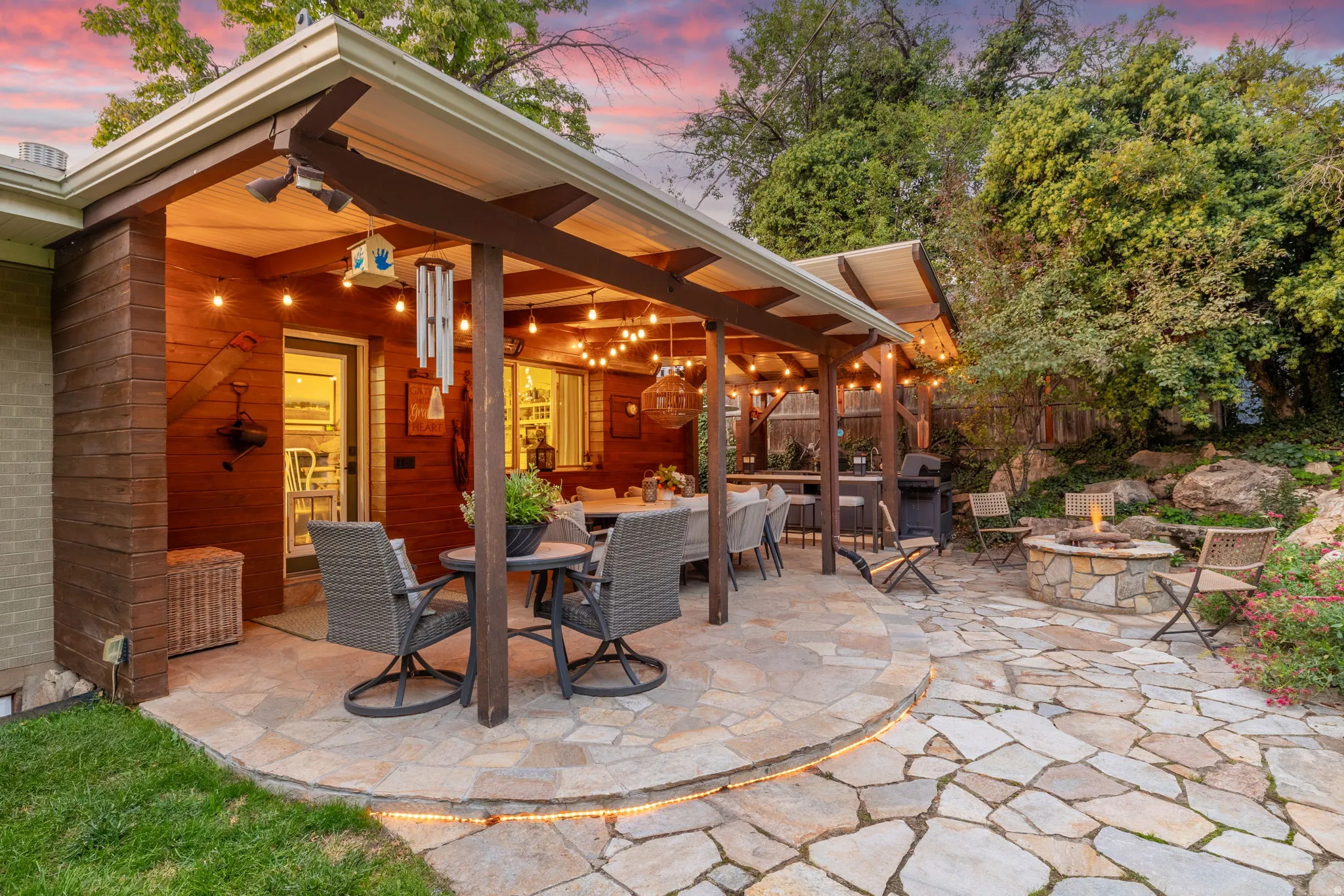 Backyard patio with hardwired heaters, firepit, dining space and kitchenette