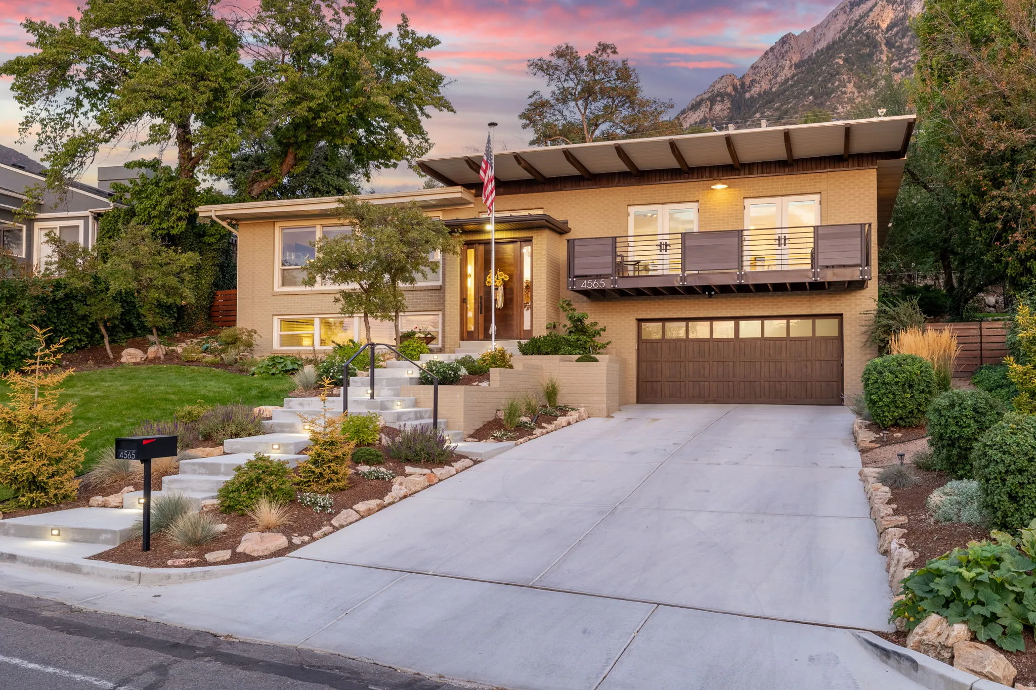 View of front of house with a balcony, a garage, driveway, and brick siding