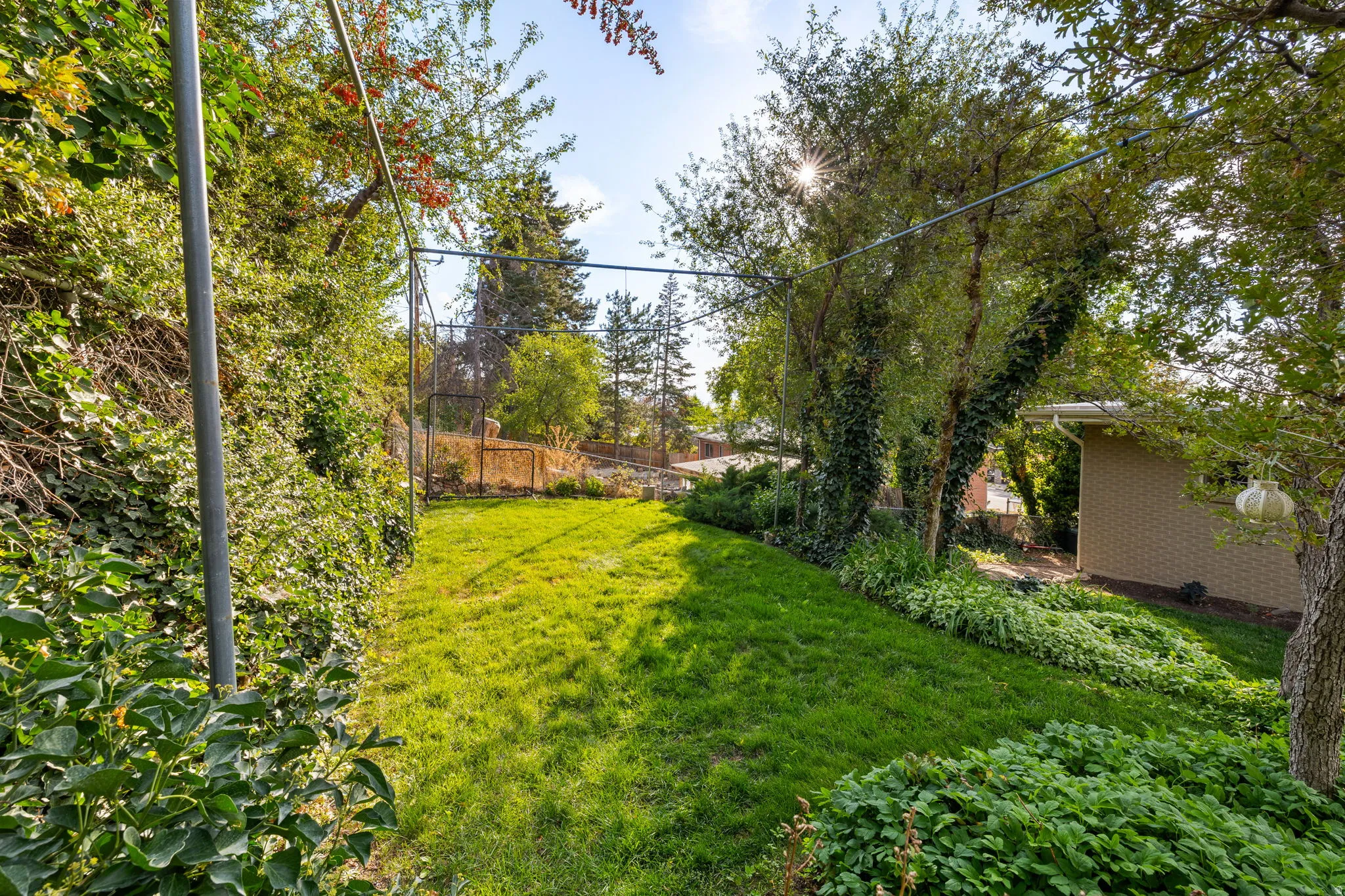 View of fenced yard and mature landscaping