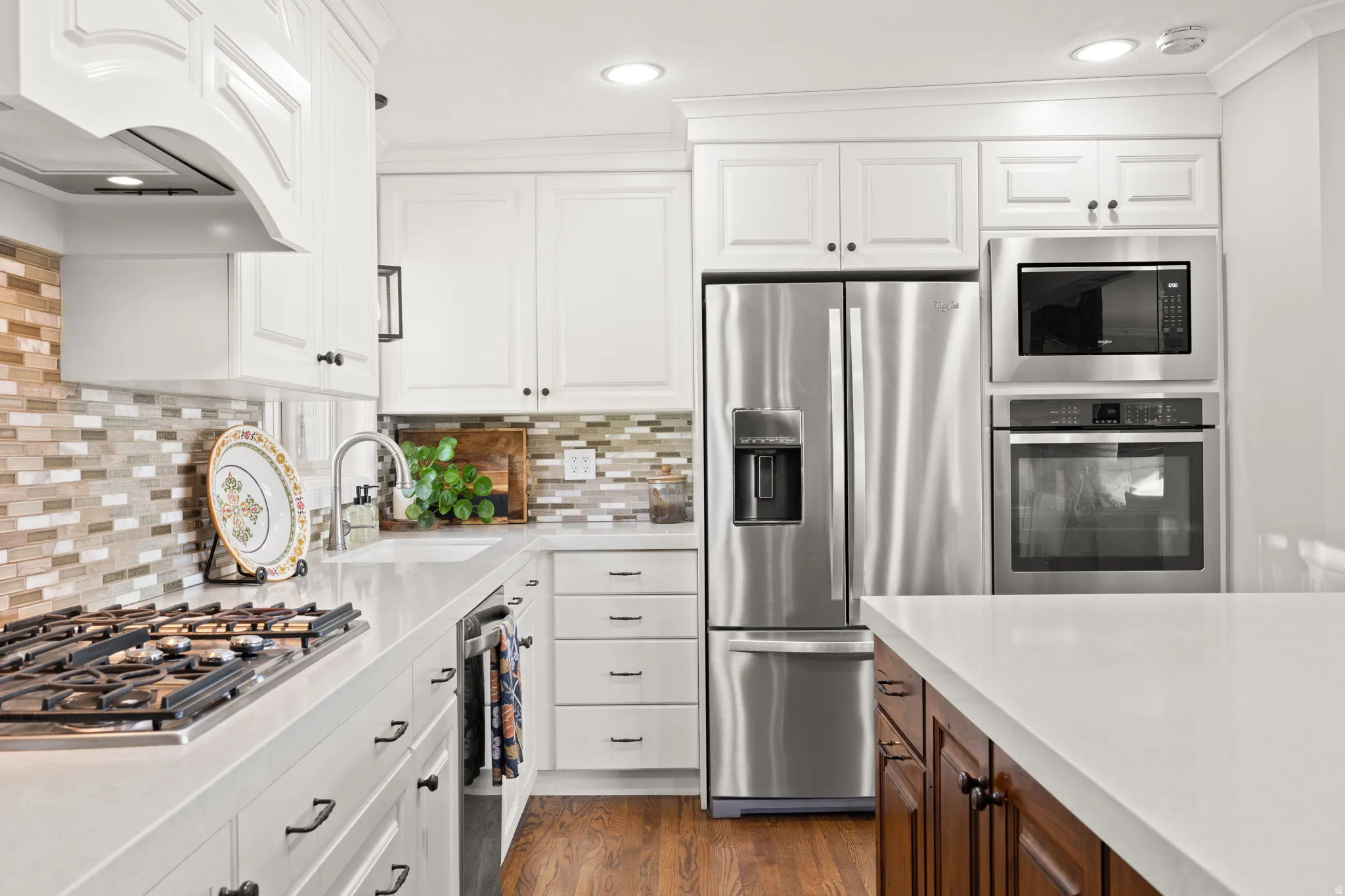 Kitchen featuring gas cooktop, double ovens, quartz countertops and updated cabinetry