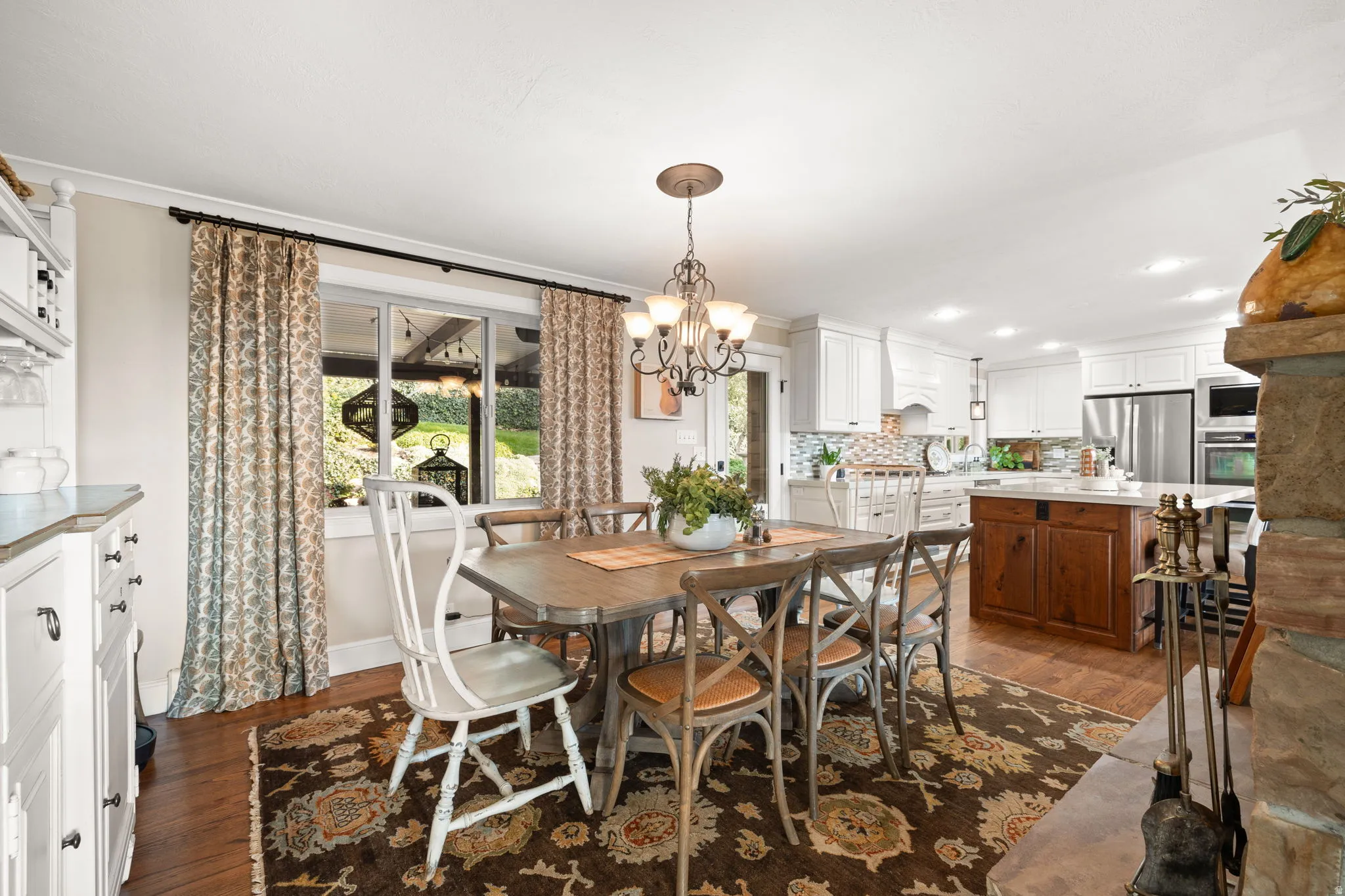 Dining room featuring hardwood floors, wood burning fireplace & access to backyard patio