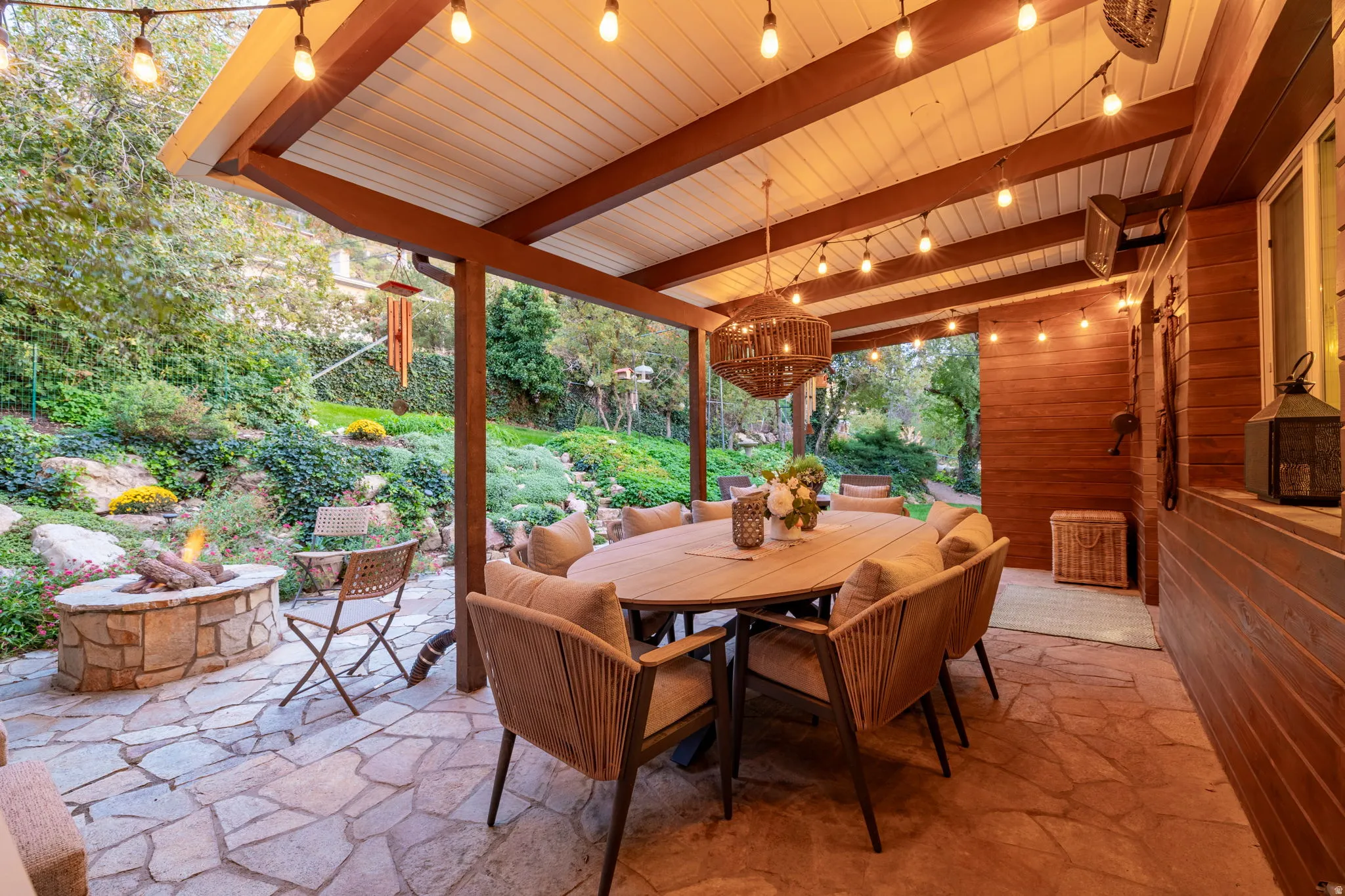 Backyard patio with hardwired heaters, firepit, dining space and kitchenette