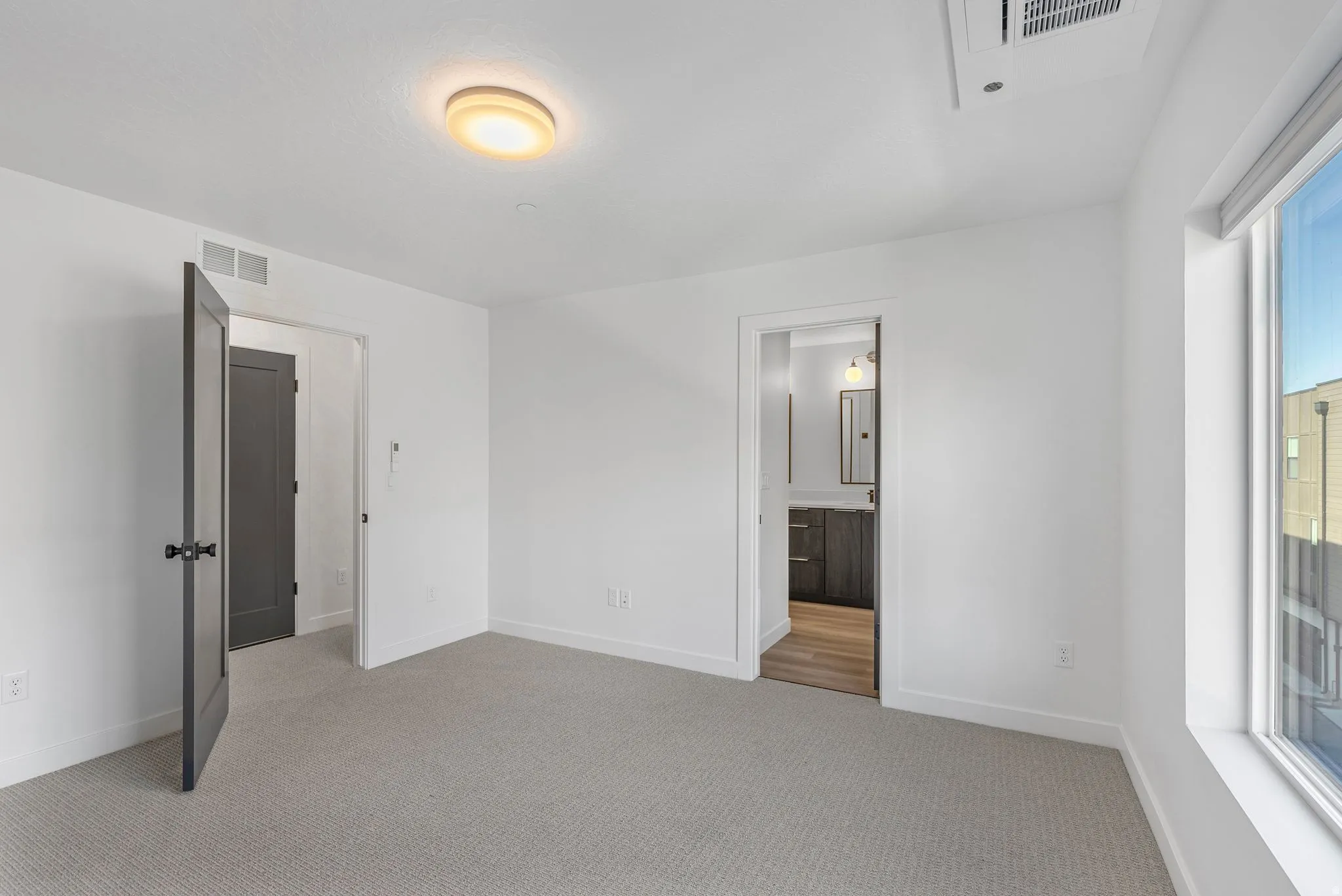 Photos are of a finished unit - Unfurnished bedroom featuring light carpet and ensuite bathroom
