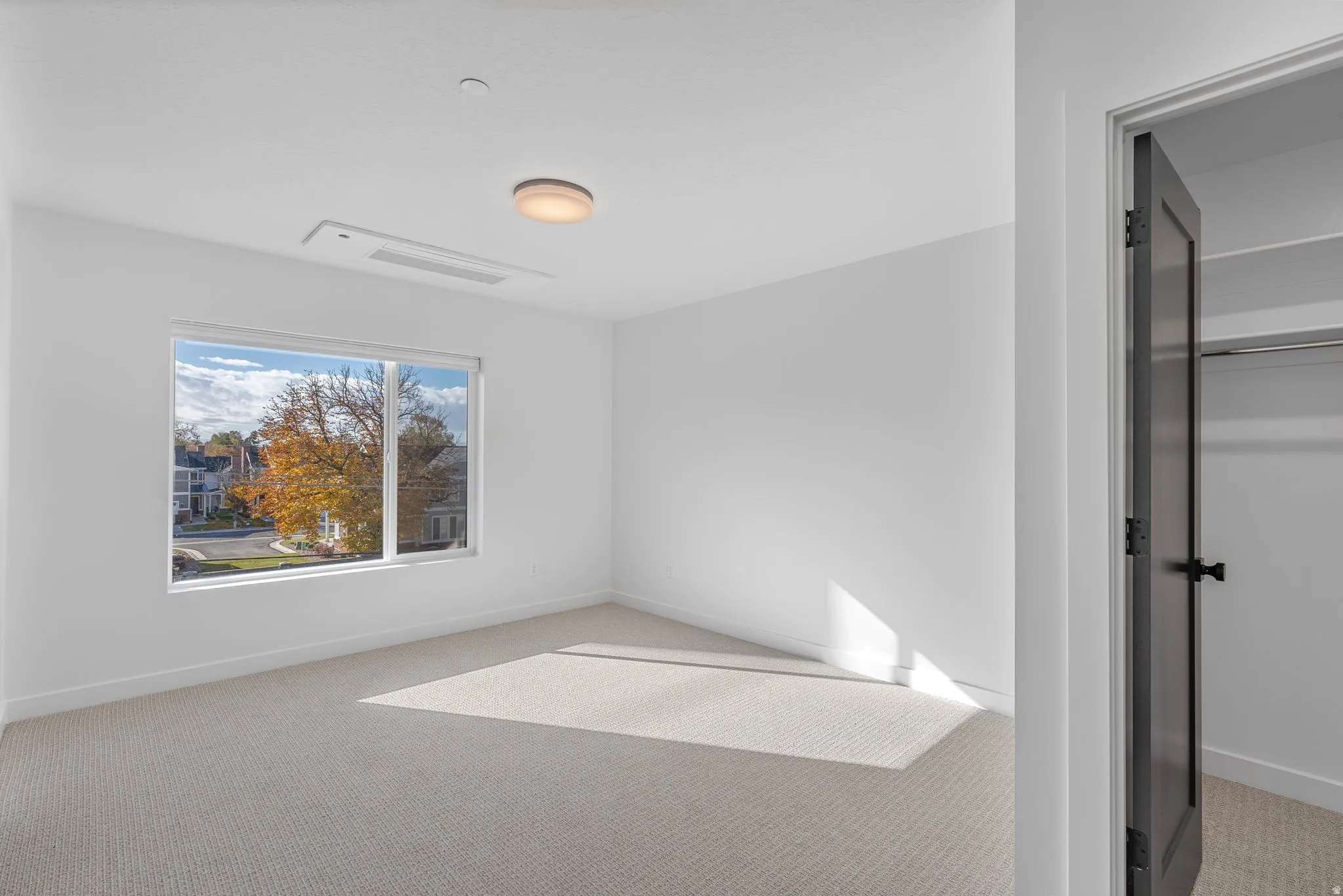 Photos are of a finished unit - Unfurnished bedroom featuring light colored carpet and a spacious closet