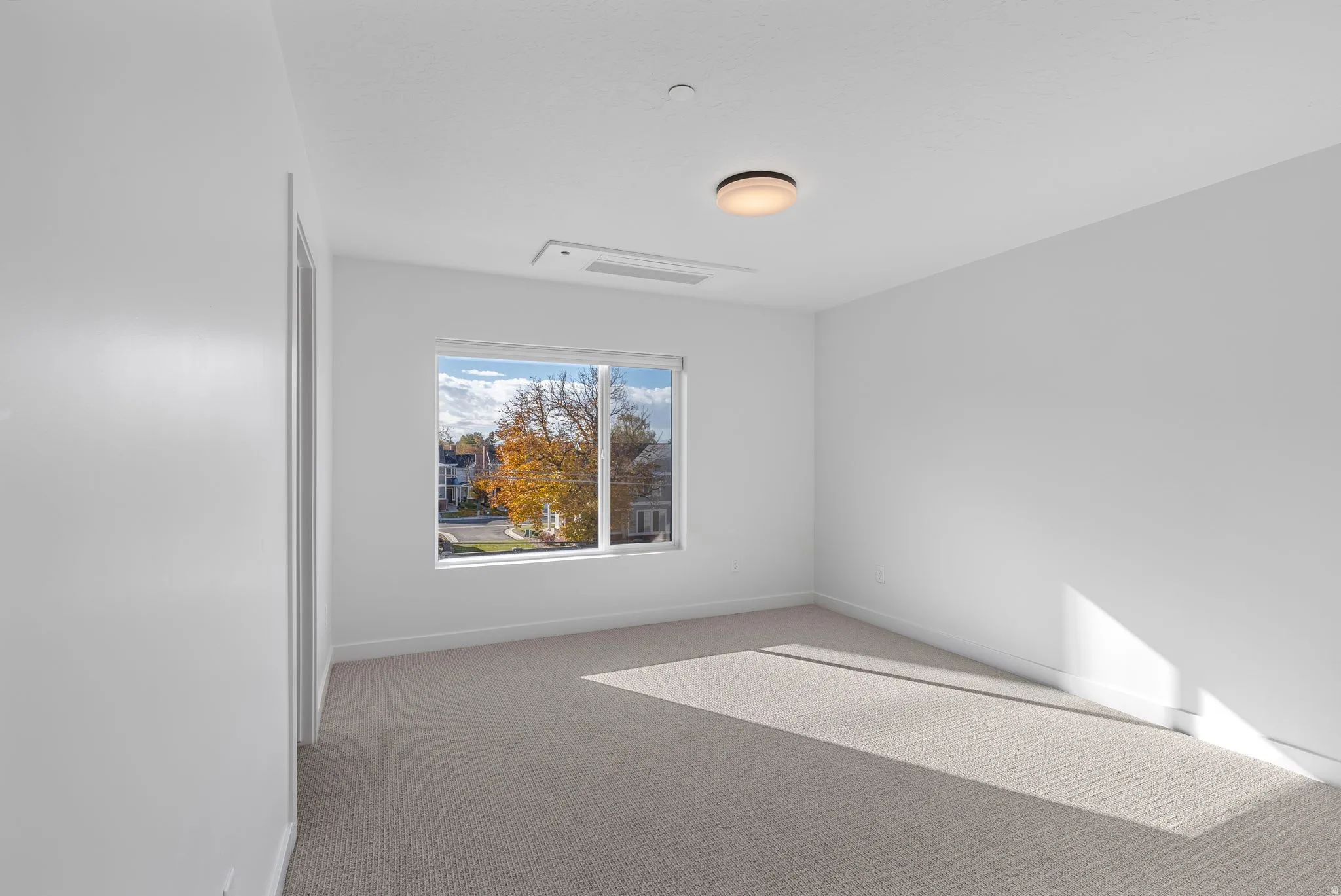 Photos are of a finished unit - Empty room featuring light colored carpet and baseboards