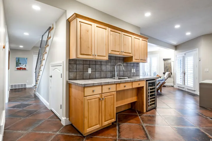 Kitchen featuring wine cooler, tile counters, recessed lighting, backsplash, and light wood finish cabinets