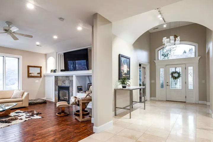 Entryway featuring healthy amount of natural light, a ceiling fan, a chandelier, a high ceiling, and a tiled fireplace