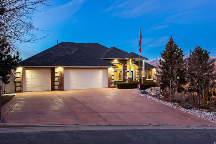 View of front of property featuring a garage, concrete driveway, and brick siding