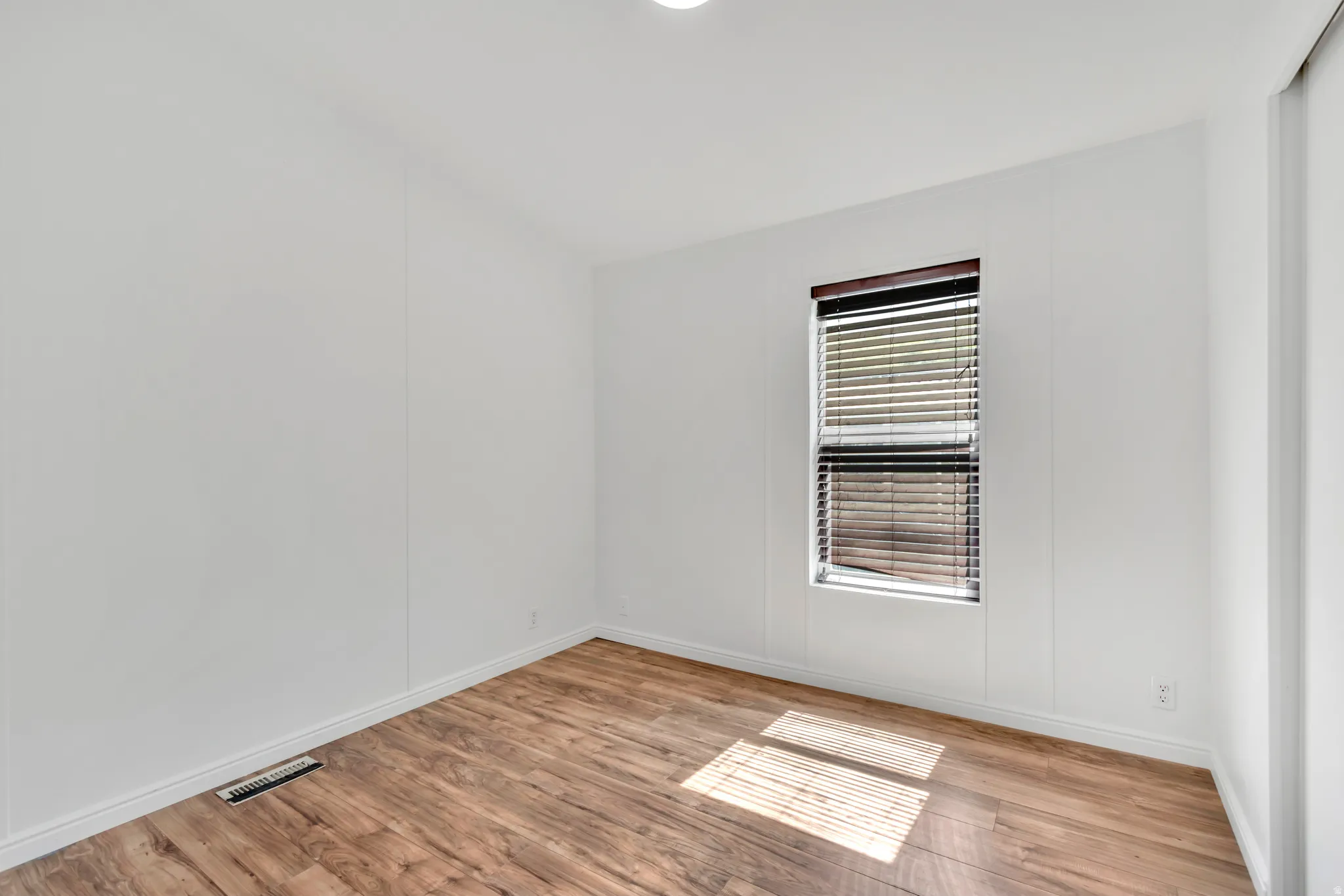 Empty room with light wood-style floors and baseboards