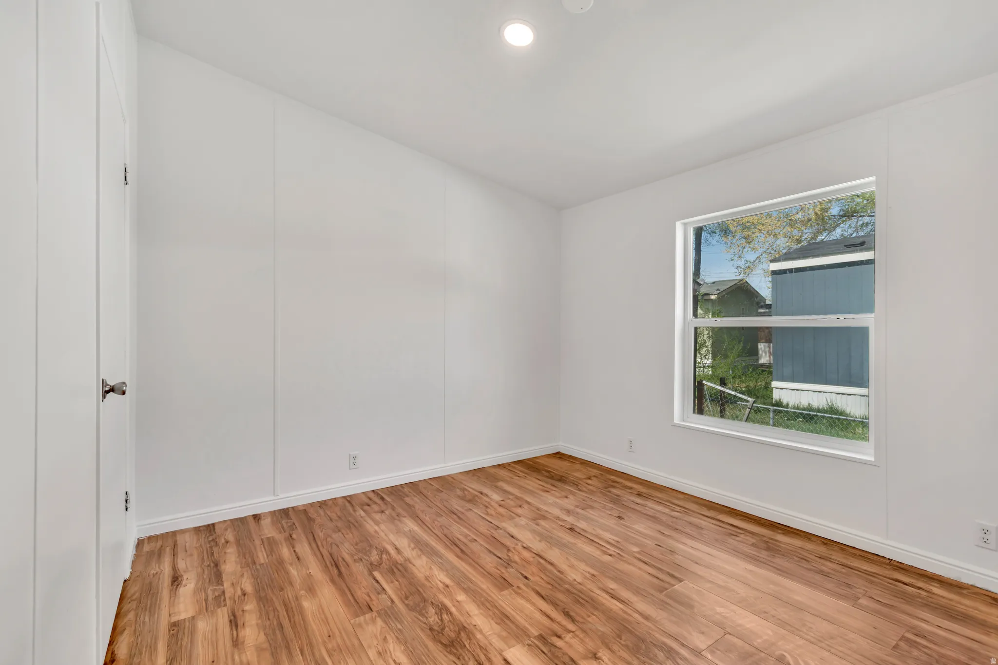 Empty room featuring light wood-style flooring, recessed lighting, and a decorative wall