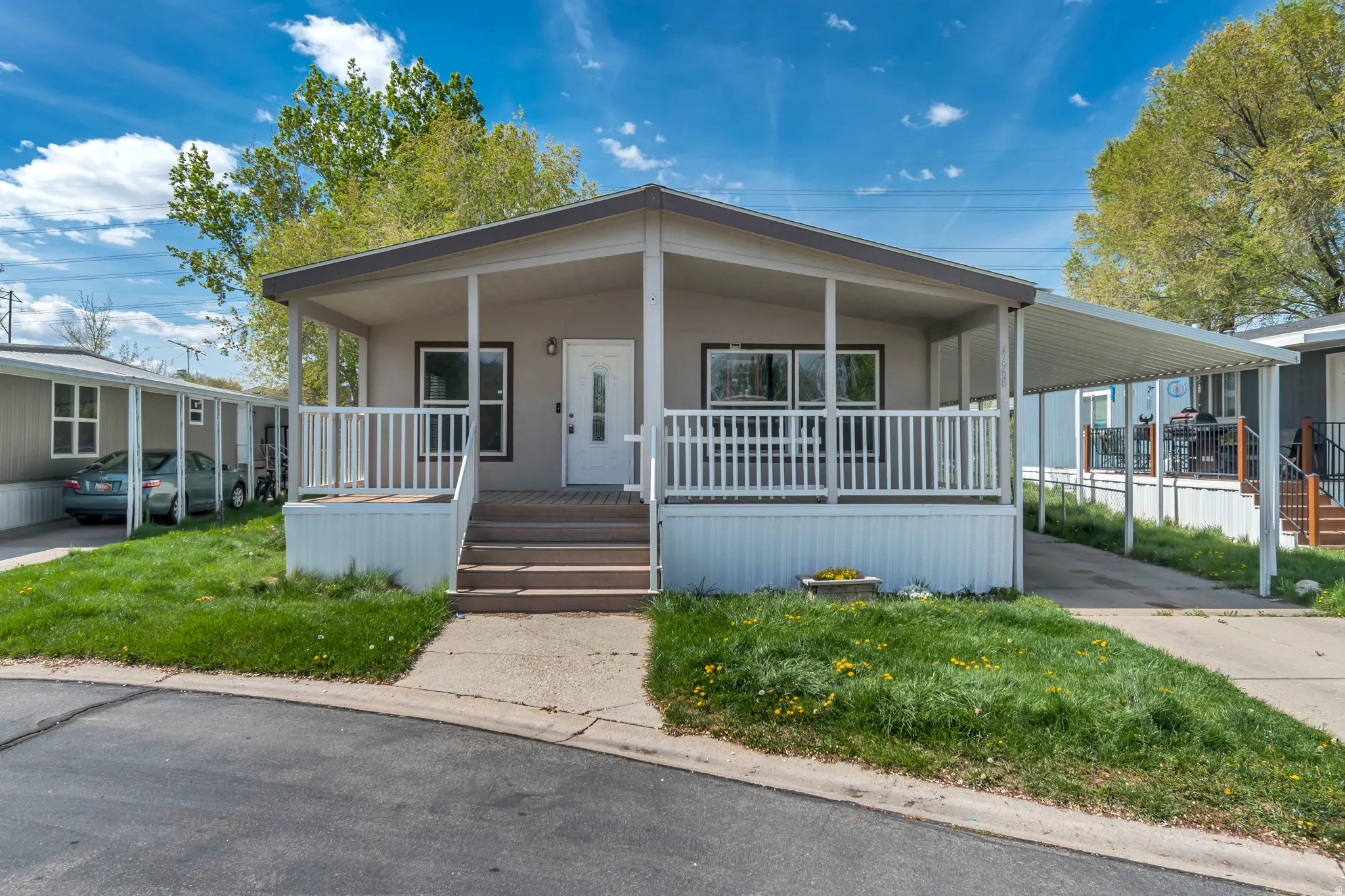 Manufactured / mobile home with an attached carport, covered porch, and concrete driveway